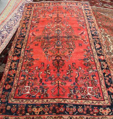 A LILIAN CARPET, with large central motif on a red ground, dark blue border