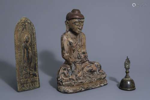 A wooden Buddha, a votive bronze plaque and a ritu...