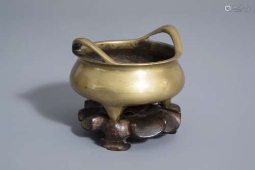 A Chinese bronze tripod censer on wooden stand, Xu...