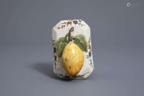 A polychrome Dutch Delft model of a lemon on a bas...