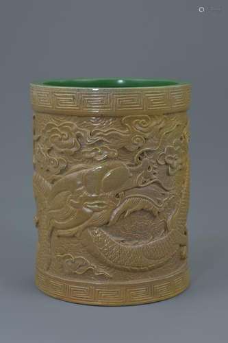 A Chinese porcelain brush pot carved with five claw