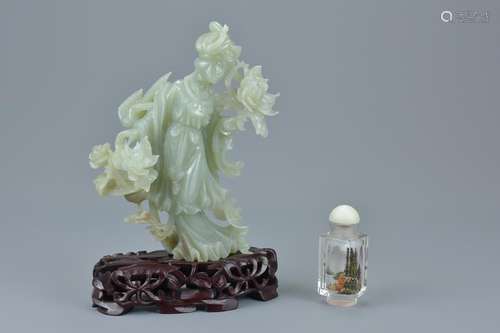 A Chinese jade figure of a Goddess holding flowers on a