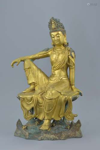 A Chinese gilt bronze figure of Guanyin seated on a