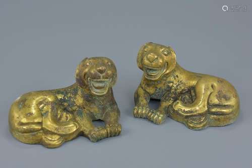 A pair of Chinese gilt bronze figures of resting lions.