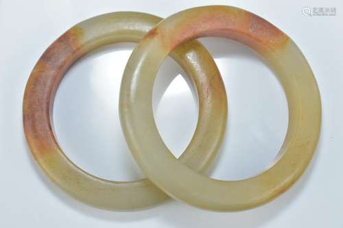 Two Chinese celadon and brown jade bangles. 8.5cm