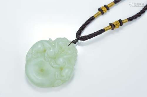 A Chinese carved jade Bi disc pendant surmounted with