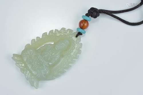 A Chinese carved pale celadon jade pendant carved as a