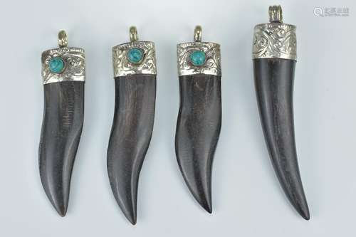 Four carved horn pendants with white metal mounts with