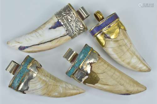 Four animal tooth pendants with white metal mounts with