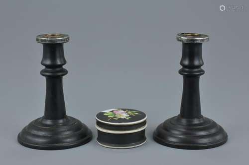 A pair of ebony wood candle sticks with silver mounts.