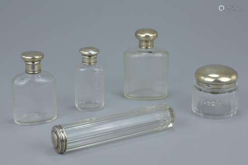 Five Victorian cut glass and silver capped bottles and