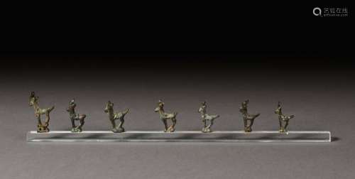 Set of seven ibex shaped pendants. \n \nBronze with …