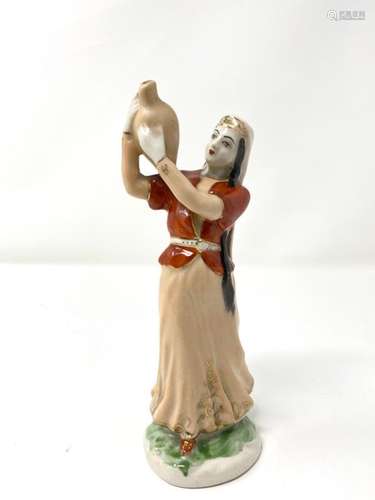 A polychrome porcelain figure with gold highlights…