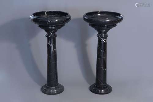 A pair of black gray marble pedestals with a bowl,...