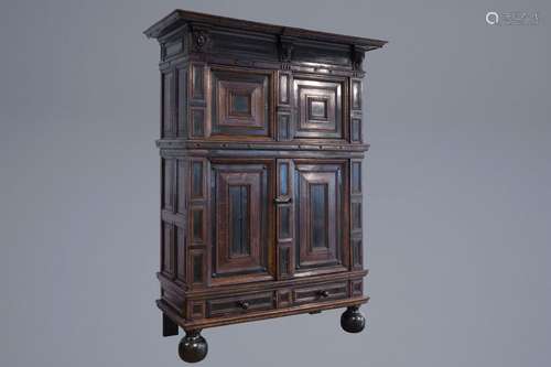 A Flemish oak and ebonised wooden cushion cupboard...