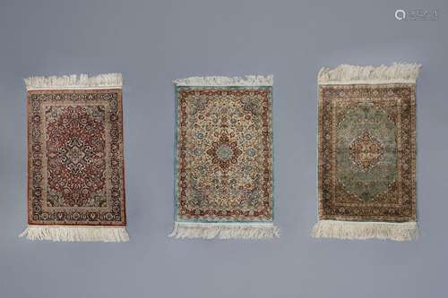 Three Oriental rugs with floral design and a centr...