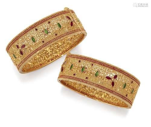A pair of bangles, of pierced hinged hoop design with green and red enamel accents, each internal