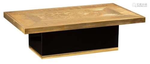 An etched brass coffee table, supported by a black…