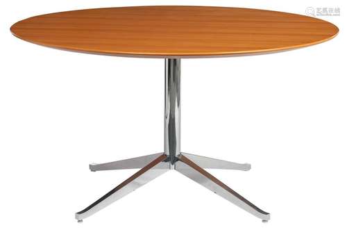 A round dining table, with a chromed base and a pe…