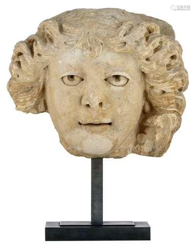 A sandstone head fragment of a man, on a metal sta…