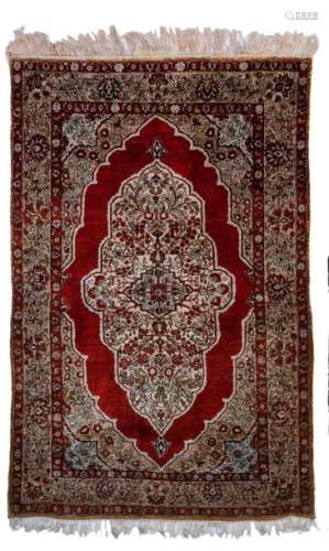 An Oriental silk rug, decorated with floral motifs…