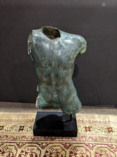 A patinated figural sculpture of a male torso