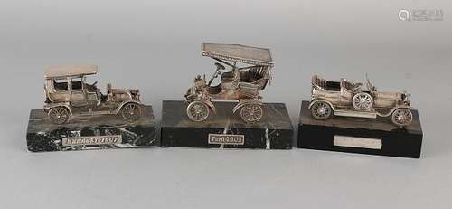 Three silver cars on basement. 835/000. A Ford 1903, a