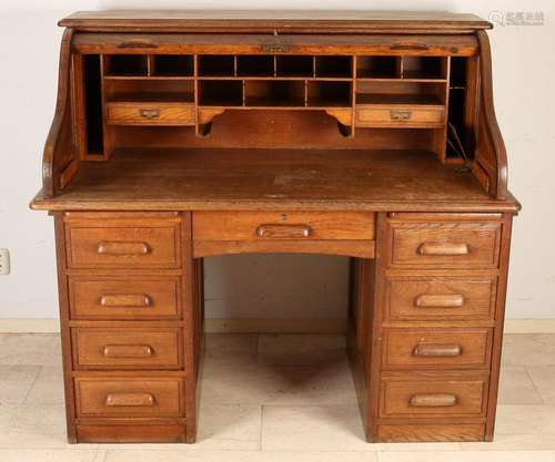 Antique oak rolbureau with various panels and drawers.