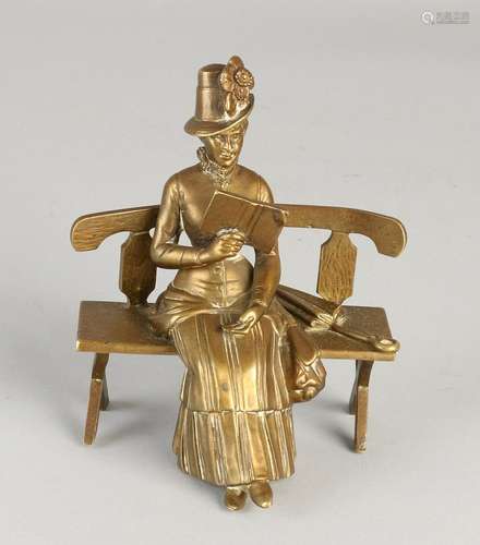 Antique bronze figure. Woman reading on bench. Circa