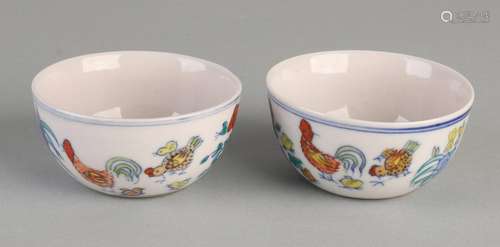 Two Chinese porcelain cups with chicken decor and text.