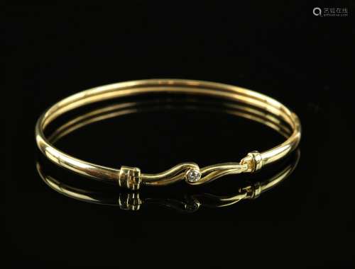 Oval gold bangle, set with round brilliant cut diamond, estimated weight 0.06 carats, mounted in 9