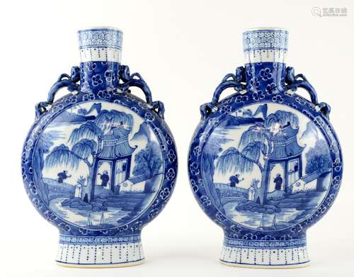 A pair of blue and white pilgrim flasks; each one about 30 cm high, and decorated with scholars