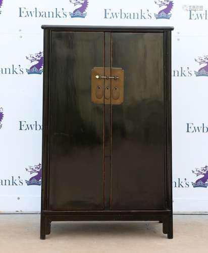 A Chinese black-lacquered cabinet of typical trapezoid form; the hinged doors opening to reveal a