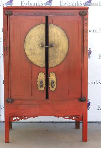 A Chinese scarlet lacquered cabinet with central, circular fitting across the hinged doors; 107 x 61