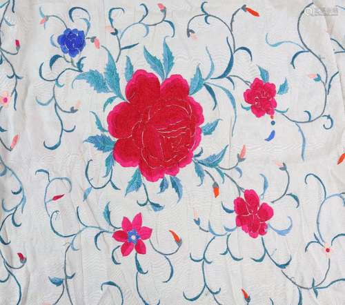 A Chinese textile shawl, decorated with bold red flower heads and scrolling linear motifs on an