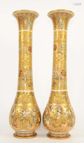 A tall pair of Satsuma vases; each one with trumpet neck, decorated in typical colours and gilt with