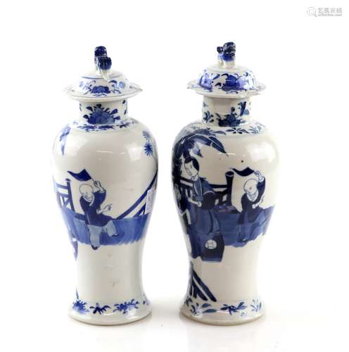 A pair of Chinese blue and white vases; each one with a domed cover and dog-of-fo finial,