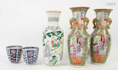 A pair of Canton famille rose vases; each one with typical trumpet neck, decorated with panels of