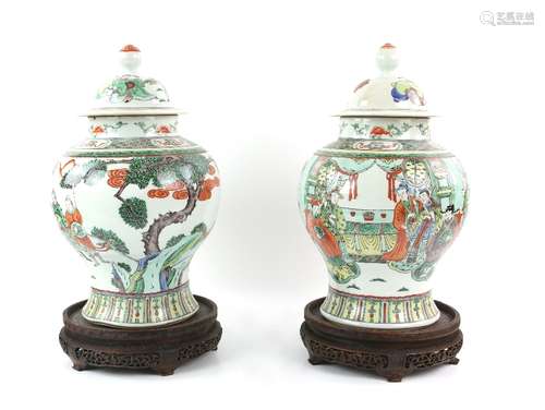 A pair of polychrome enamel Chinese vases; each one with domed cover and knop finial, decorated with