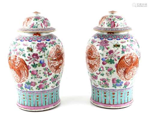 A pair of famille rose 'potiche'; each one with a domed cover and decorated with dragon and