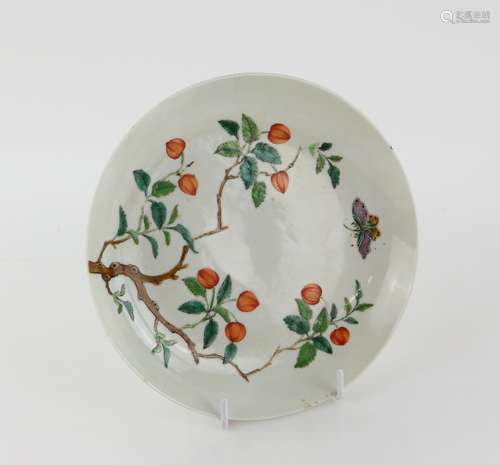 A famille rose dish of circular form, decorated with a butterfly flying above lychees in fruit;