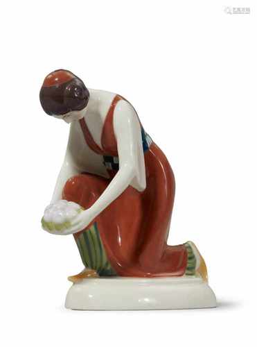 A Berlin KPM porcelain figure of a kneeling Turkish lady with a dish of fruitModel no. 9447. Stamped