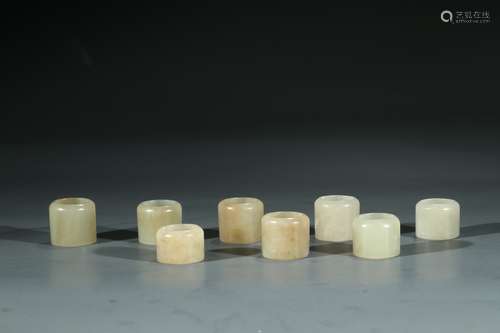 A SET OF EIGHT WHITE JADE ARCHER'S RINGS