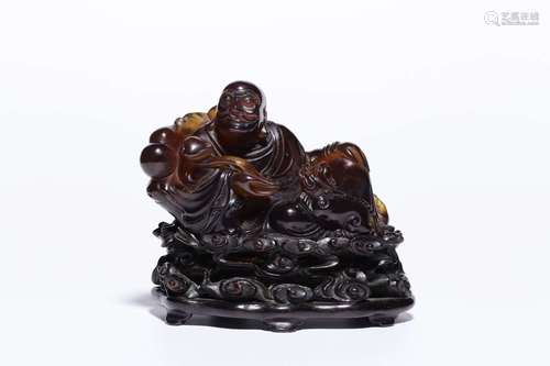 A QING DYNASTY AMBER SITTING FIGURE