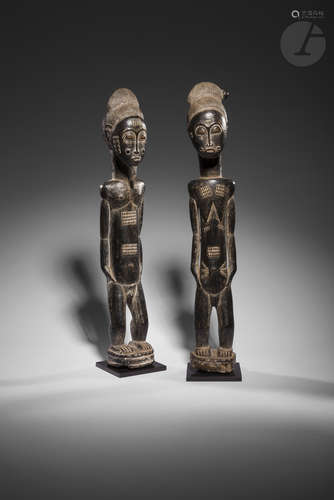 Un couple de statuettes masculine et féminine aux corps richement scarifiés, aux coiffes tressées,