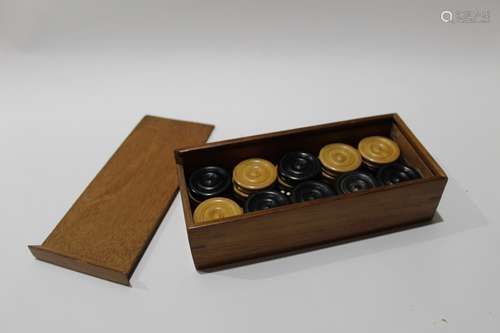 Mahogany case containing vintage draughts pieces and dominoes