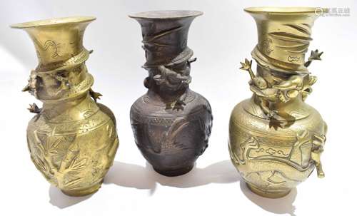 Group of three Oriental metal vases, all decorated in relief with dragons to the neck with further