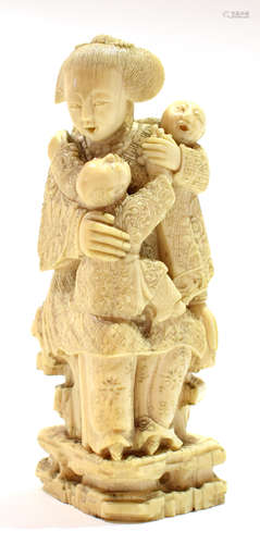 Ivory Okimono, Meiji period, of a lady with two children seated on a chair, 10cm high