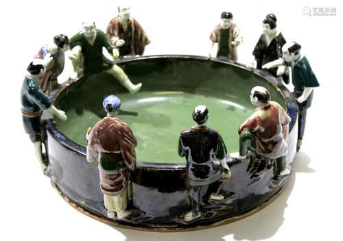 Unusual Japanese pottery bowl, the rim surrounded by ten Japanese figures in various poses,