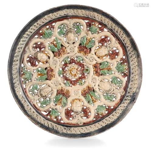 CIRCULAR CUTTING IN GLAZED GROUND, PRÉ D'AUGE OR MANERBE, 17th CENTURY with openwork decoration in relief enhanced with polychrome in the centre of a rosette surrounded by faces draped among foliated foliage and fleurons on a background of interlacing, the reverse side with a marbled background.